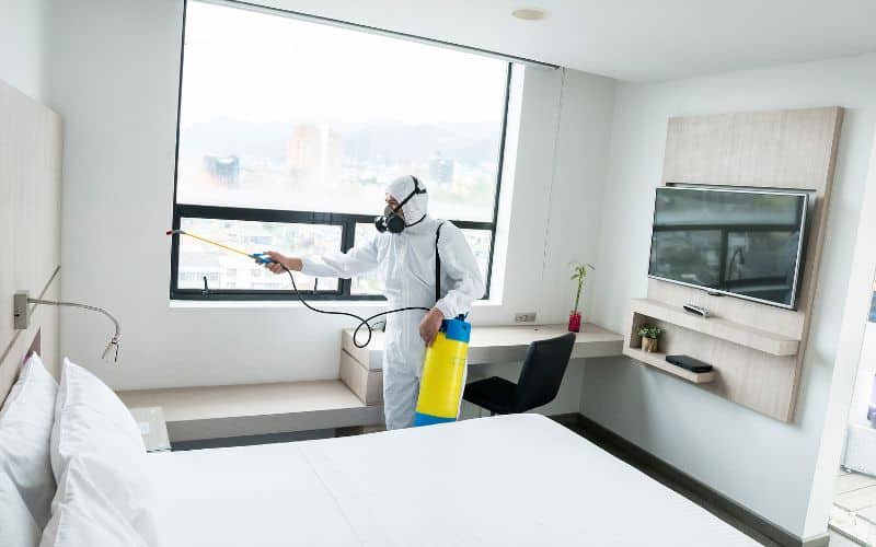 Worker disinfecting hotel room to prevent Covid 19