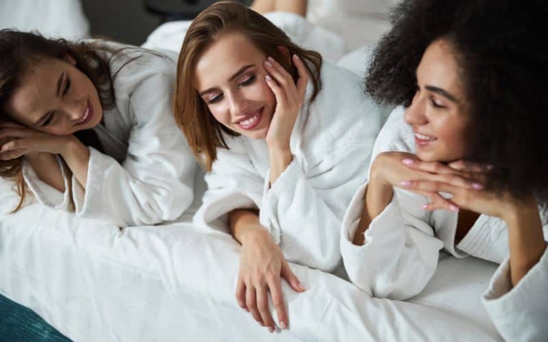 Three friends chilling on hotel bed