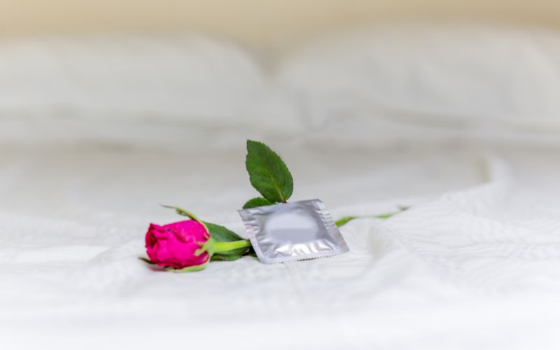 Condom and flower on hotel bed