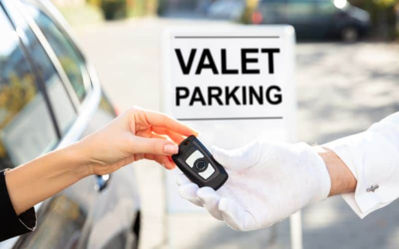 Woman giving car key to male valet