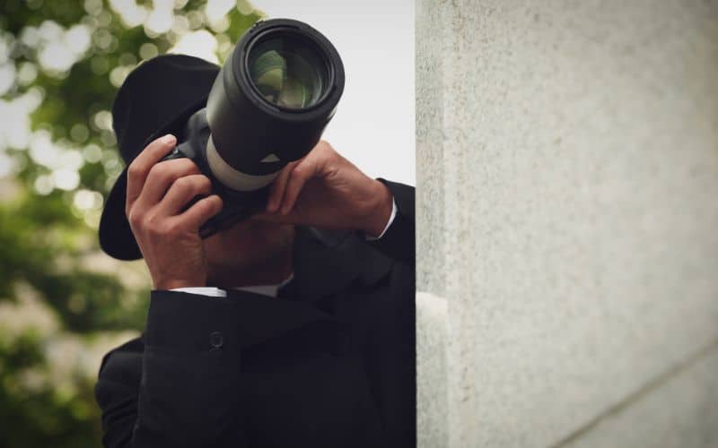 Private investigator with modern camera spying