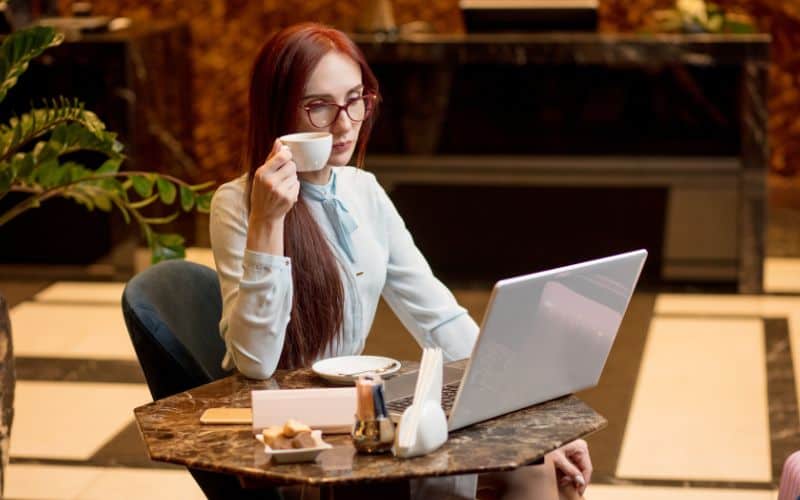 Business woman working on laptop and drinking coffee